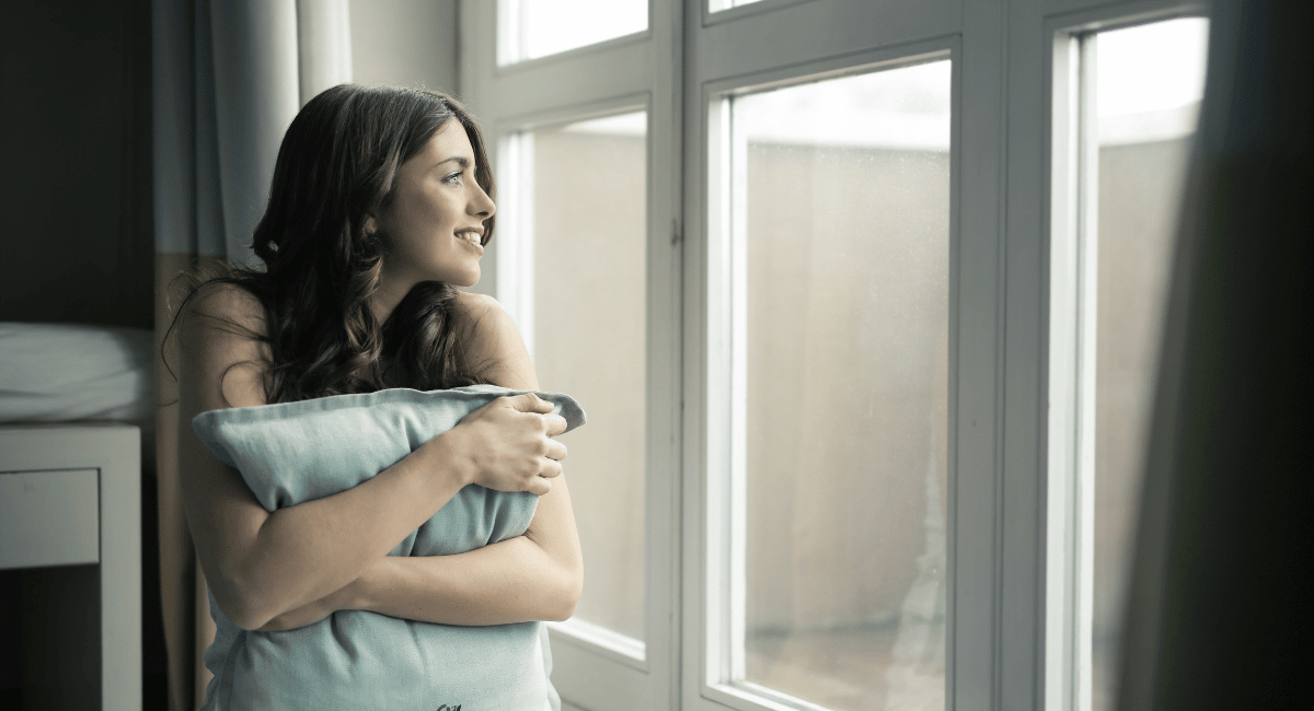 Beautiful woman smiling while looking outside the window
