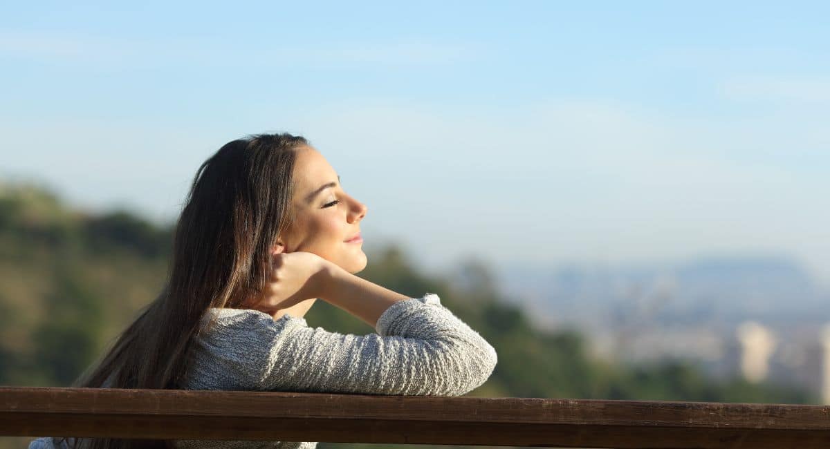 woman sitting on the bench feeling relaxed outdoor